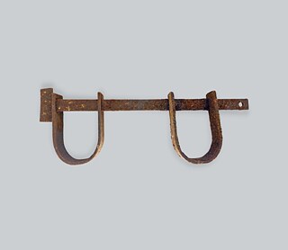 Nachbildung einer horizontalen Handschelle, Instrument, welches zur Folter von Versklavten verwendet wurde. Objekt aus dem Museu da Capitania de Ilhéus, 2022 Nachbildung einer horizontalen Handschelle, Instrument, welches zur Folter von Versklavten verwendet wurde. Objekt aus dem Museu da Capitania de Ilhéus, 2022