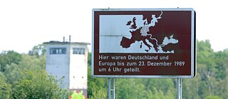 Natur und Geschichte auf einer Radtour entlang des Grünen Bandes: Ein Hinweisschild zum ehemals geteilten Deutschland steht an der Landstraße 5 bei Schrampe in der westlichen Altmark an der ehemaligen innerdeutschen Grenze.